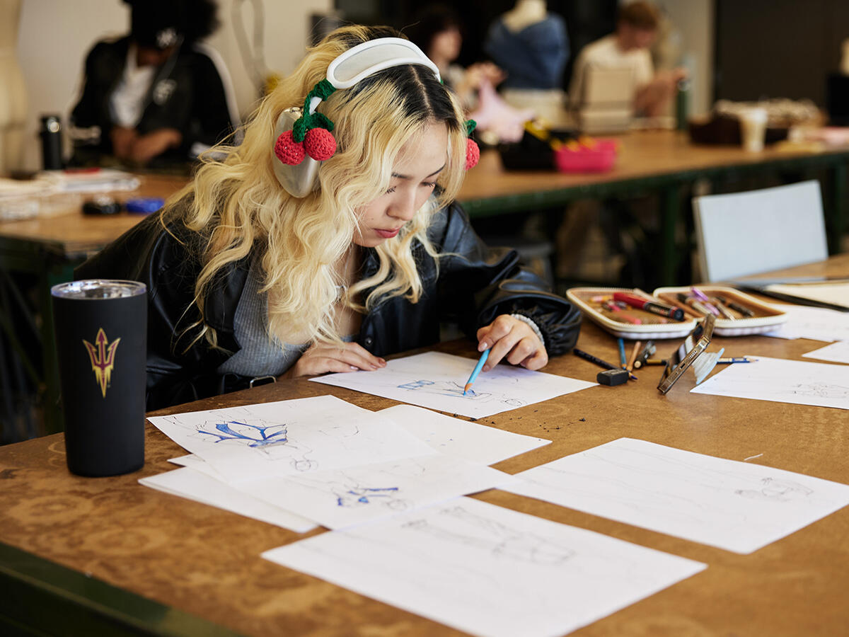 ASU FIDM student drawing at a desk