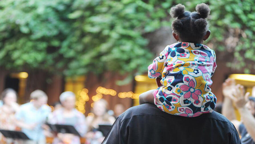 Person walking with child on shoulders