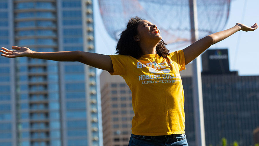 Student walking with arms held high